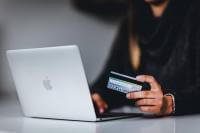 Woman with a laptop holding a credit card